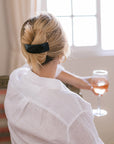 Woman with straight, blonde hair styled in a twist updo with a France Luxe large, Black barrette.