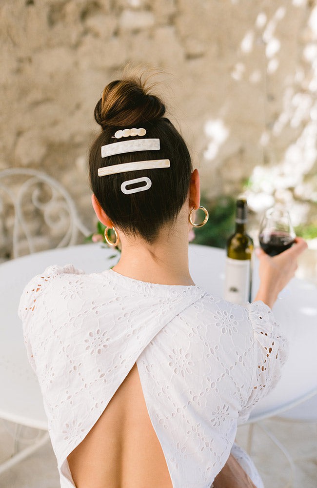 Woman with straight, brown hair styled in an updo with a France Luxe small barrette, marbled ivory white.