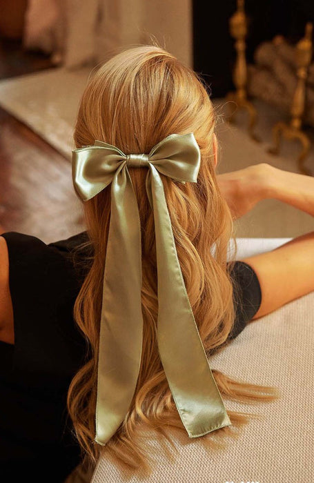 Sage green silk bow hair clip on barrette clasp holding back wavy blone hair, Long Tail Bow Barrette, Silk Charmeuse Sage by L. Erickson USA, handmade in America