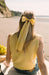 Yellow silk bow hair clip holding back hair at the beach, Long Tail Bow Barrette, Silk Charmeuse Plantain by L. Erickson USA, handmade in America