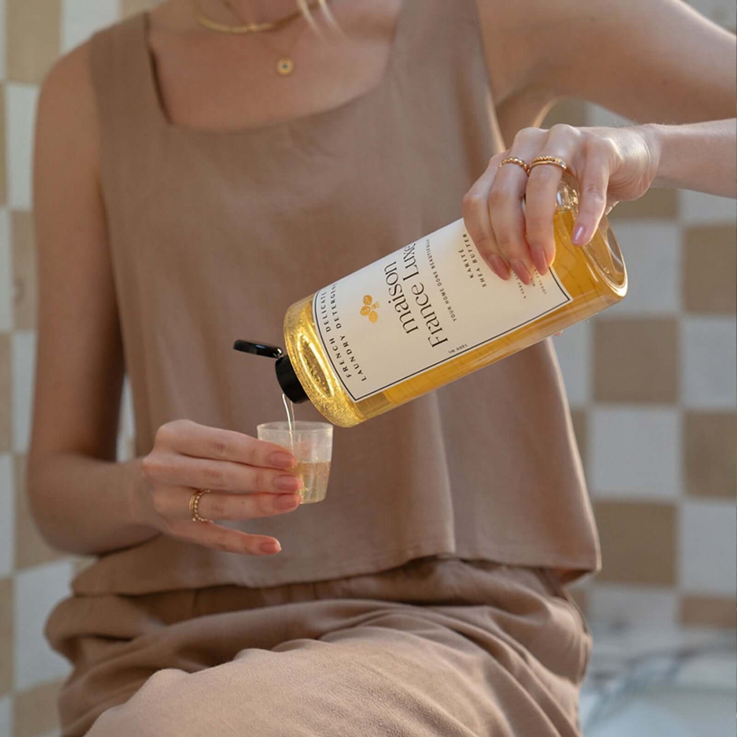 Person measuring laundry detergent for delicate made by Maison France Luxe.
