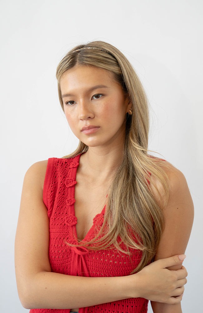 France Luxe thin headband in a marbled gray and charcoal color, pictured holding straight, blonde hair in a loose hairstyle.