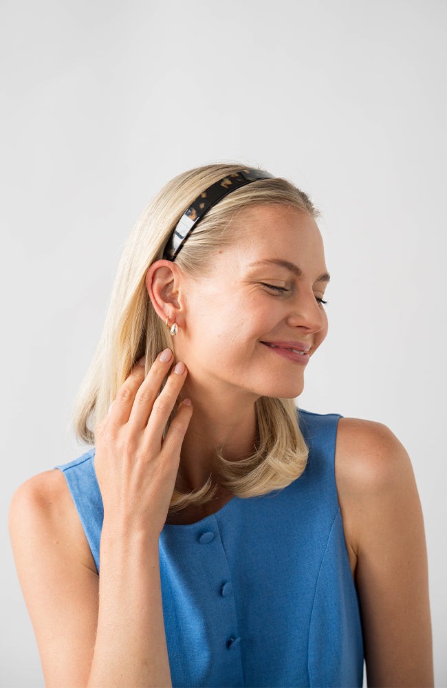 France Luxe Tortoise Shell headband for women pictured holding straight, blonde hair in a loose hairstyle.