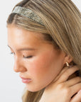 France Luxe pixelated mosaic of silver with black headband for women pictured holding straight, blonde hair in a loose hairstyle.