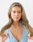 France Luxe pixelated mosaic of silver with black headband for women pictured holding straight, blonde hair in a loose hairstyle.