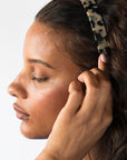 France Luxe Ivory Tortoise Shell headband for women pictured holding curly, brown hair in a loose hairstyle.