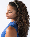 France Luxe Ivory Tortoise Shell headband for women pictured holding curly, brown hair in a loose hairstyle.
