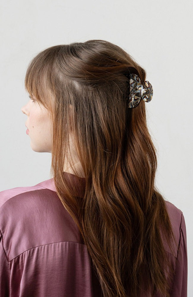France Luxe small French claw hair clip for women pictured holding straight, brown hair in a casual half up hairstyle.
