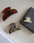 Elegant French claw hair clip in marbled gray and charcoal, shown with medium and mini sizes.