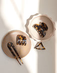 Timeless French hair accessories, Tortoise hair clips, a small triangle barrette, and a two-prong hair pin.