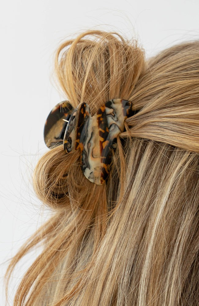 France Luxe small French claw hair clip for women pictured holding straight, blonde hair in a half up hairstyle.