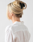 Woman with straight, blonde hair styled in an updo with a France Luxe medium claw hair clip, classic black.