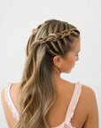 France Luxe mini French claw hair clip for women pictured holding straight, blonde hair in a braided hairstyle.