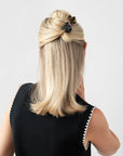 France Luxe mini, black claw hair clip for women pictured holding straight, blonde hair in a half up hairstyle.