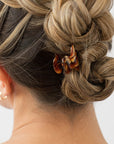 Woman with straight, blonde hair styled in a braided updo with a France Luxe mini, Brown claw hair clip.