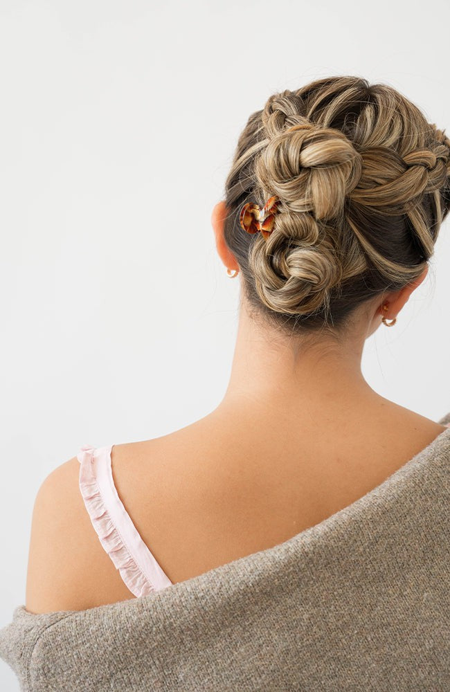 Woman with straight, blonde hair styled in a braided updo with a France Luxe mini, Brown claw hair clip.