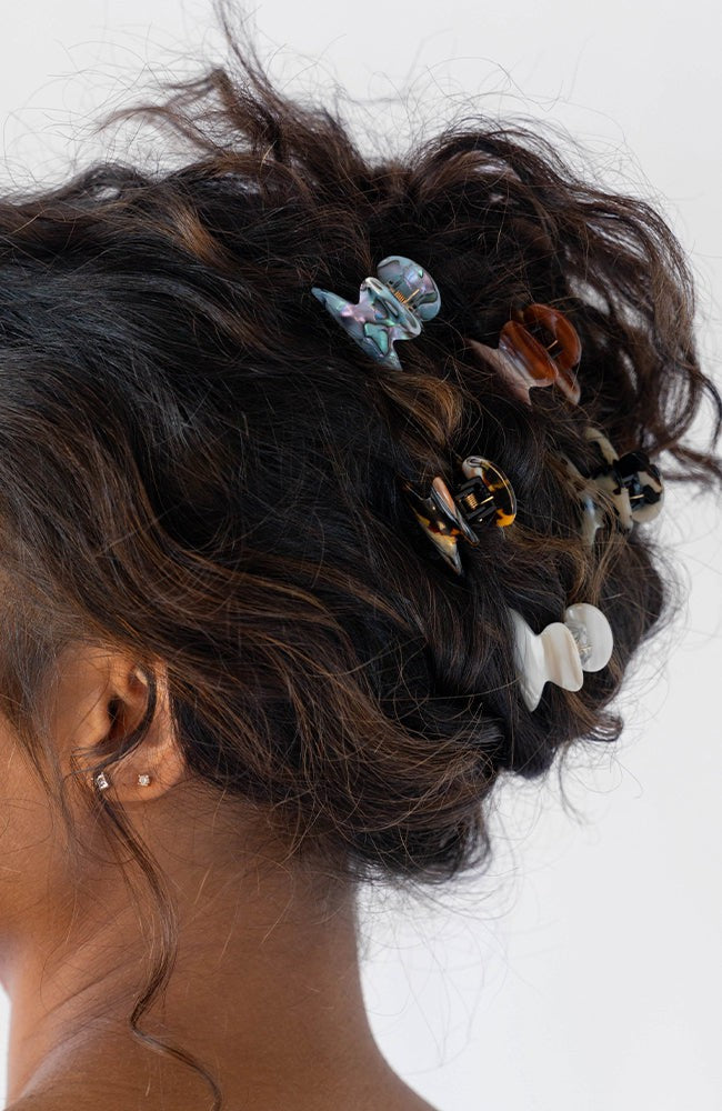 France Luxe Brown Mini Claw Hair Clip holding curly, brown hair back in a loose updo.