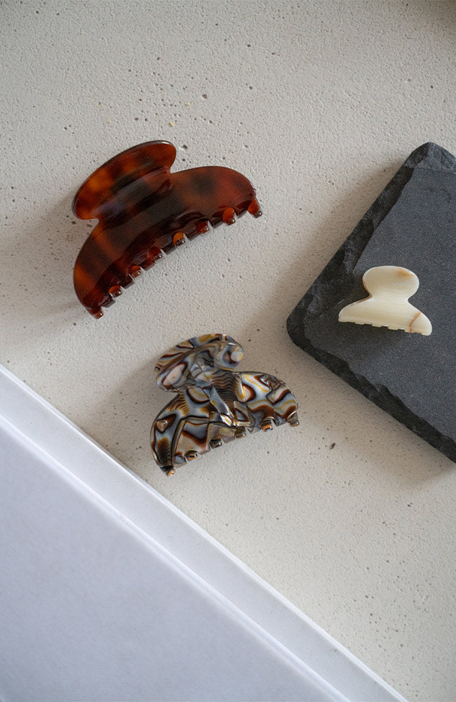 Several elegant Mini Couture French Hair Clips by France Luxe pictured on side table.