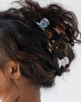 France Luxe Ivory Tortoiseshell Mini Claw Hair Clip holding curly, brown hair back in a loose updo.
