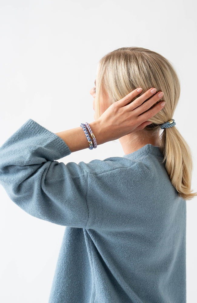 Woman with blonde, straight hair styled in a low ponytail using Blue &amp; Gold, thick hair ties.