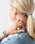 L. Erickson hair ties used to style blonde, straight hair in low ponytail, Blue & Gold.