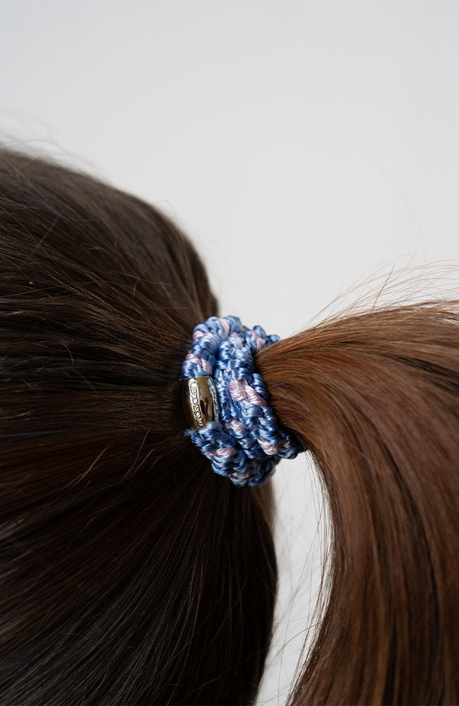 Woman with brown, straight hair styled in a sleek ponytail using Blue &amp; Gold, thick hair ties.