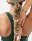 L. Erickson hair ties used to style light brown, straight hair in braided ponytail, green & orange bands.