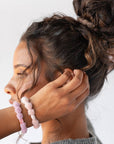 Pink hair ties for thick hair, seen on woman with curly hair. Extra thick bubble ponytail holder by L. Erickson.
