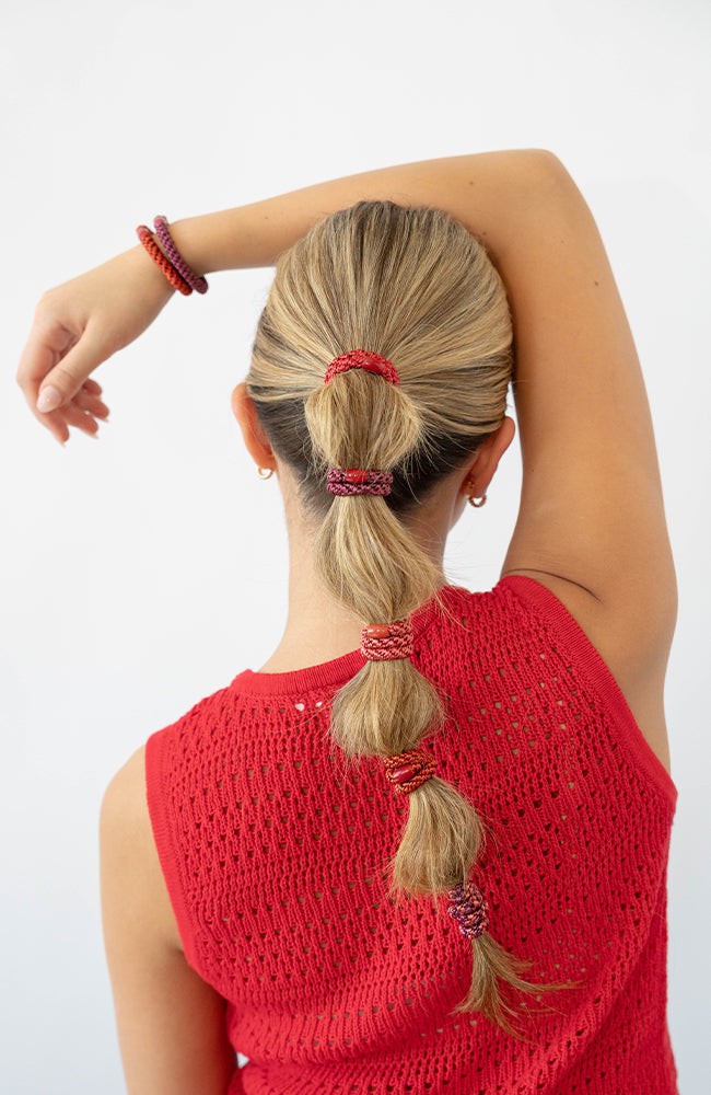 Woman using red L. Erickson hair ties for fine hair. Strong and gentle. Damage free, crease free.