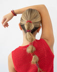 Woman using red L. Erickson hair ties for fine hair. Strong and gentle. Damage free, crease free.