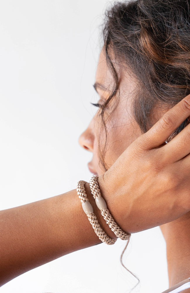 Brown hair ties for thick hair, seen on wrist. Cute ponytail holders by L. Erickson.