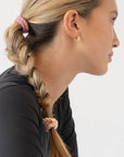 Pink hair ties styling a cute braided ponytail, straight, light brown hair. By L. Erickson.