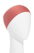 A red rust bandeau headwrap displayed on a mannequin head.