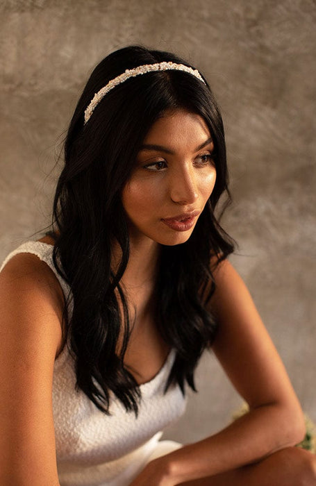 White, beaded headband by L. Erickson, pictured on a women with dark brown hair styled in loose, flowing waves