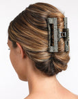 large hair clip with a cutout design, holding hair up in a twist