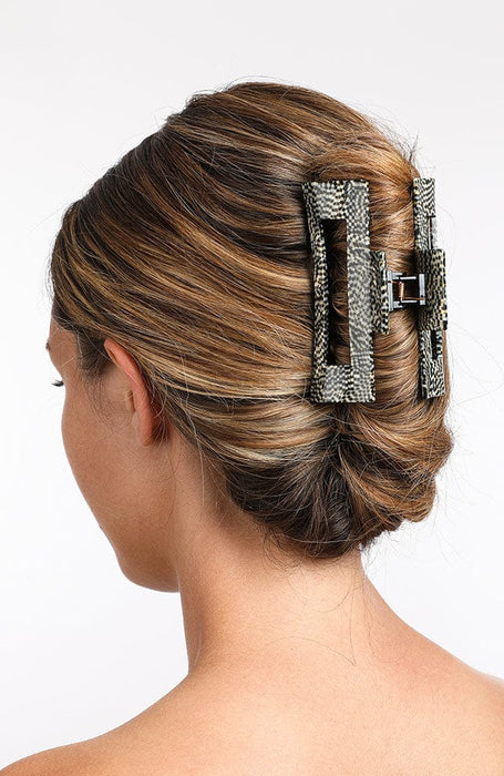large hair clip with a cutout design, holding hair up in a twist